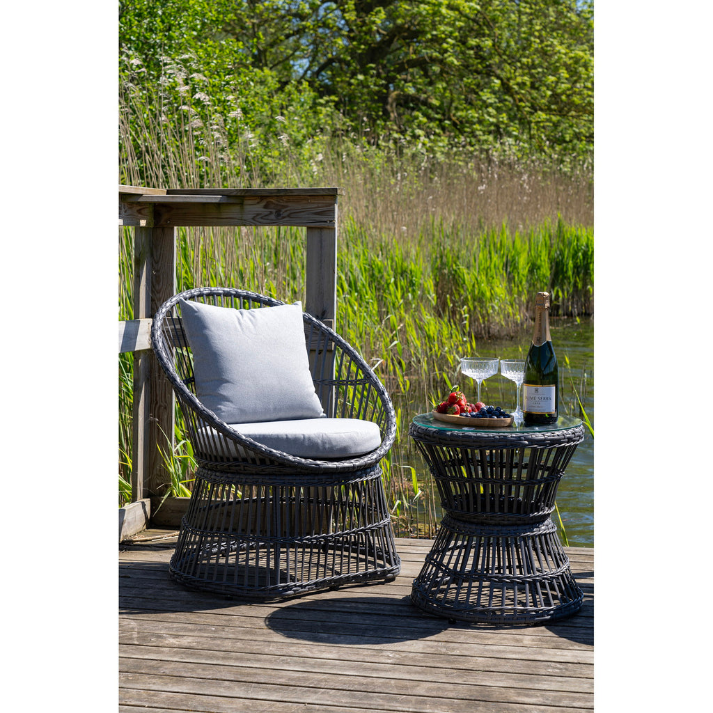 Fauteuil Natal rotin gris avec table basse verre sur ponton bord de l'eau