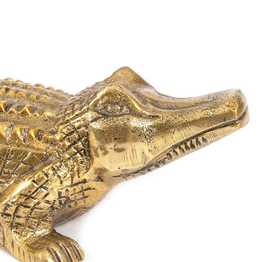 Serre-livres crocodile en aluminium finition laiton en situation