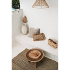 Set de table en jonc de mer sur une table basse en bois dans une pièce claire meublée de fibres naturelles
