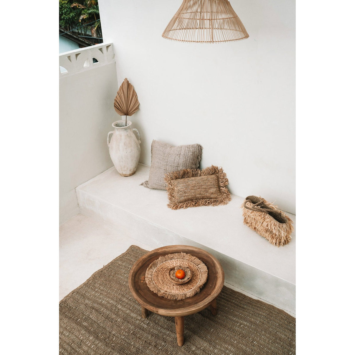 Set de table en jonc de mer sur une table basse en bois dans une pièce claire meublée de fibres naturelles