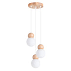 Suspension Pekka en grappe trois globes de verre opale coiffés de billes de bois sous une rosace ronde en bois