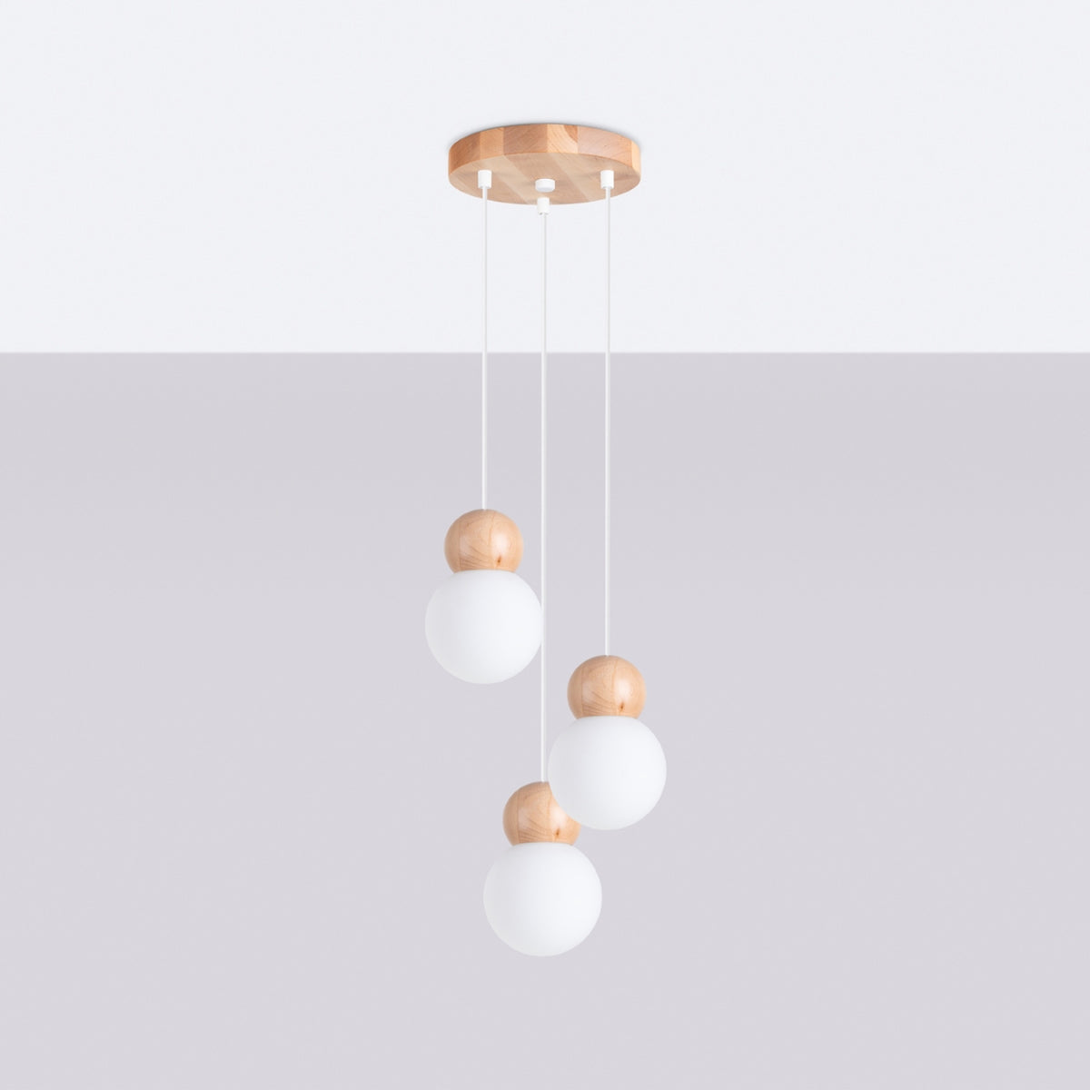 Suspension Pekka en grappe sous un plafond clair avec ses trois globes à hauteurs décalées