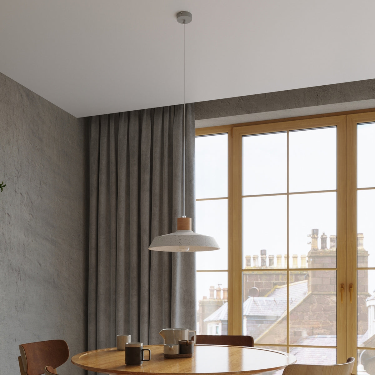 Suspension Afra en béton au-dessus d'une table ronde près d'une grande fenêtre