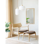 Deux suspensions Argalo verre côtelé blanc bois naturel au-dessus fauteuil bois salon scandinave