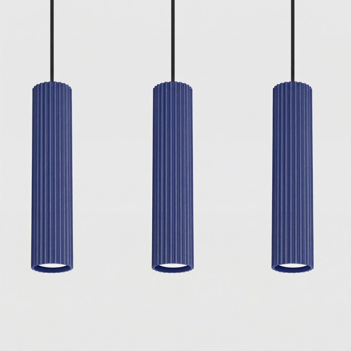 Trois tubes cannelés en laque bleu outremer vus de près sous leurs câbles