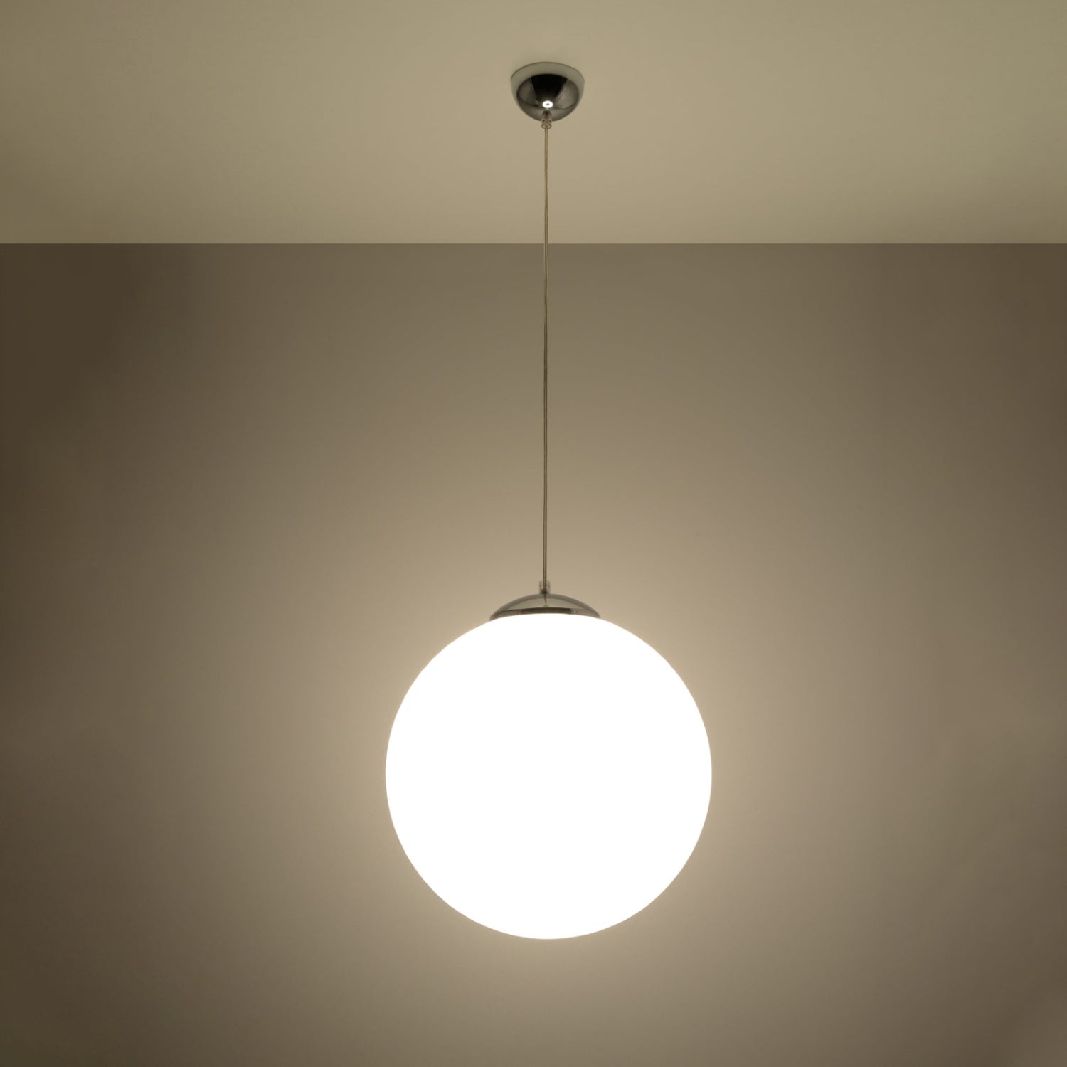 Suspension boule Ugo blanche allumée à la lumière douce