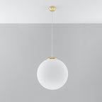 Suspension boule Ugo en verre blanc pendue sous un plafond blanc devant un mur gris