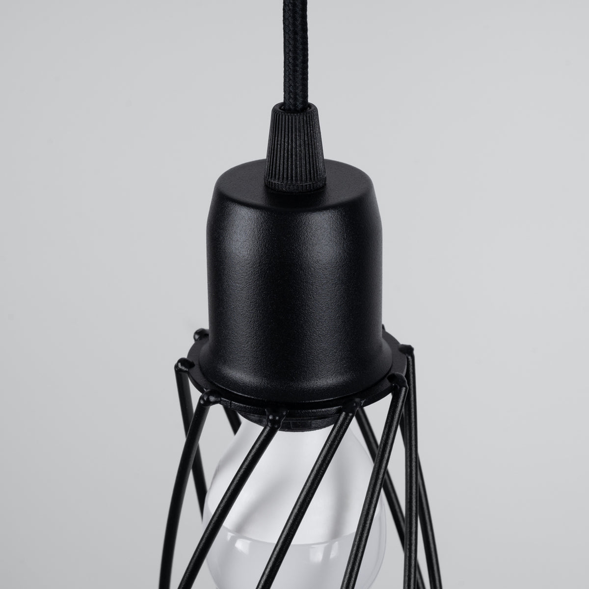 Détail de la douille noire grainée et du haut de la cage en fil d'acier de la suspension Suba