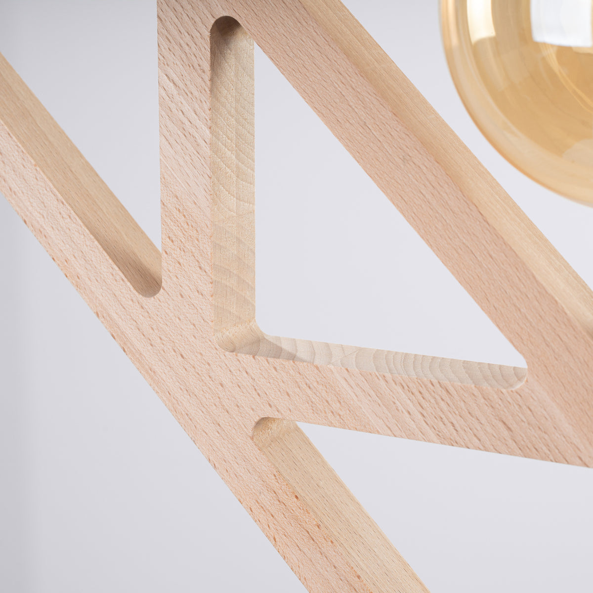 Découpes aux angles arrondis du cadre en bois naturel de la suspension Caro