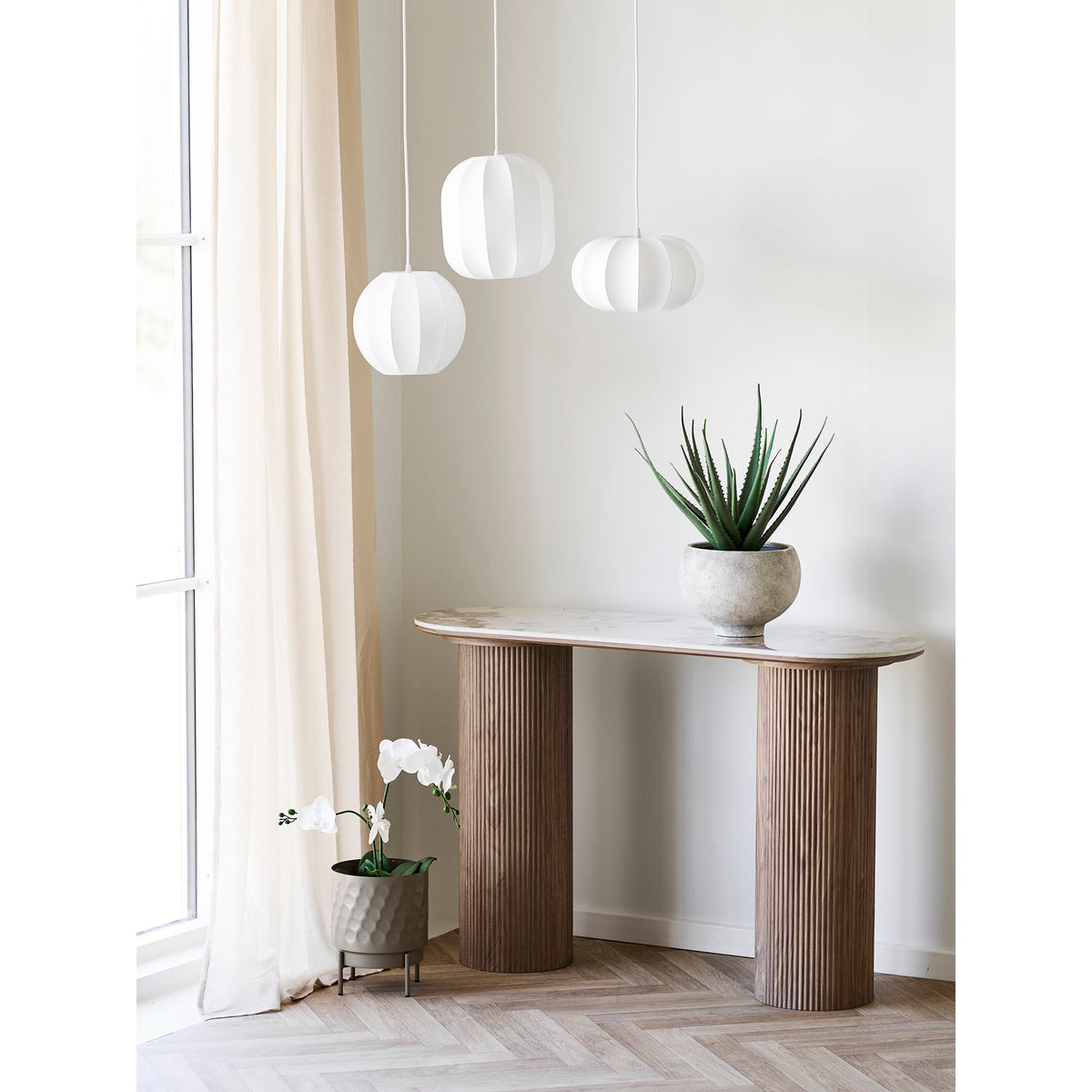 Suspension Coventry globe aplati avec deux autres formes de la ligne au-dessus d'une console à pieds cannelés