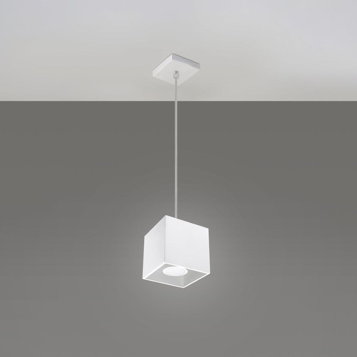 Suspension cube Quad Métal blanc allumée sous sa rosace carrée sur fond uni
