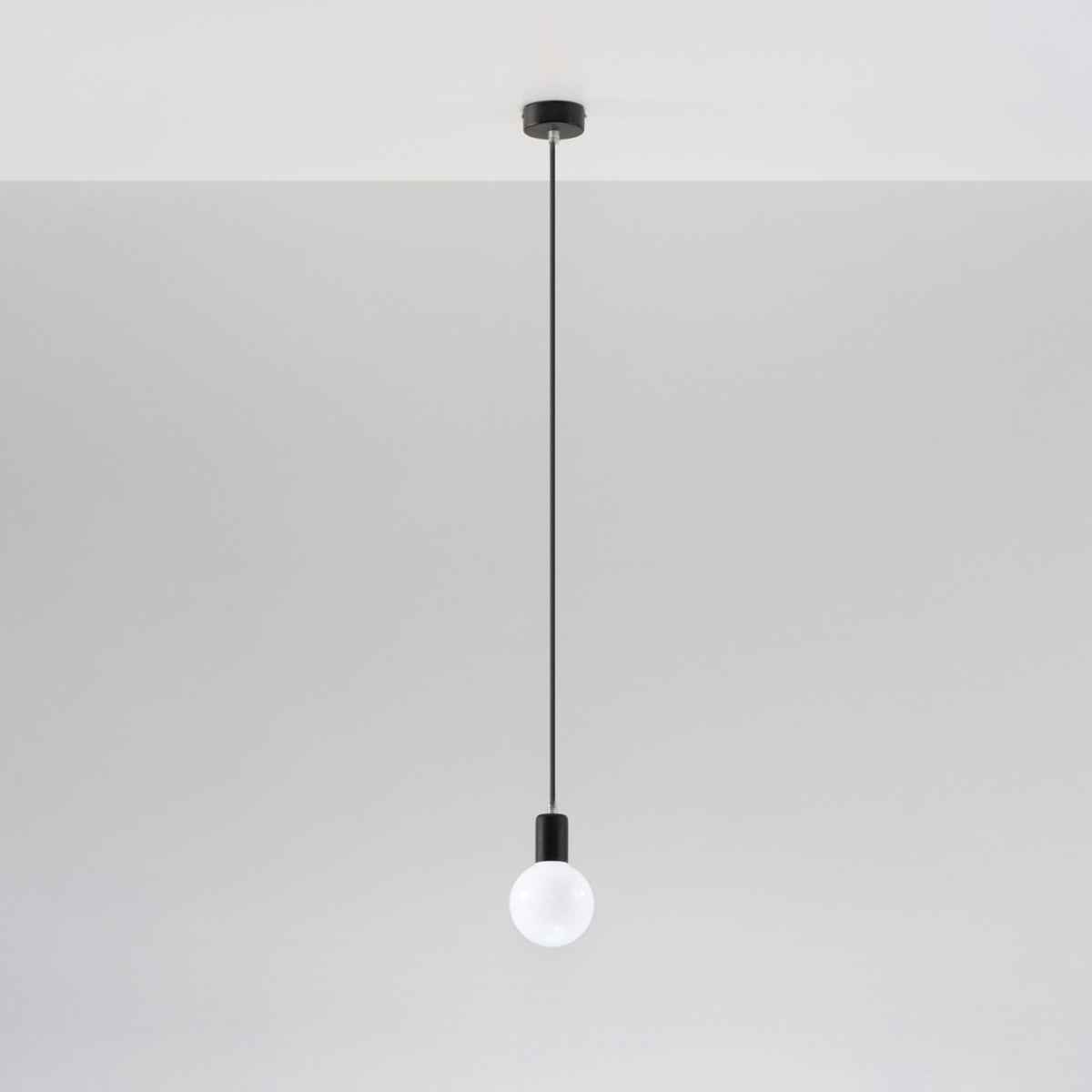 Suspension Edison noire avec ampoule globe opale sous un plafond blanc