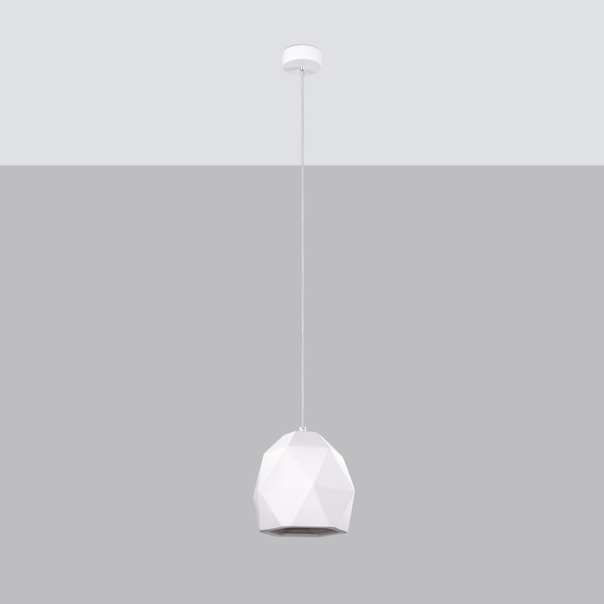 Suspension Mint en céramique blanche pendue à son câble blanc devant un mur gris