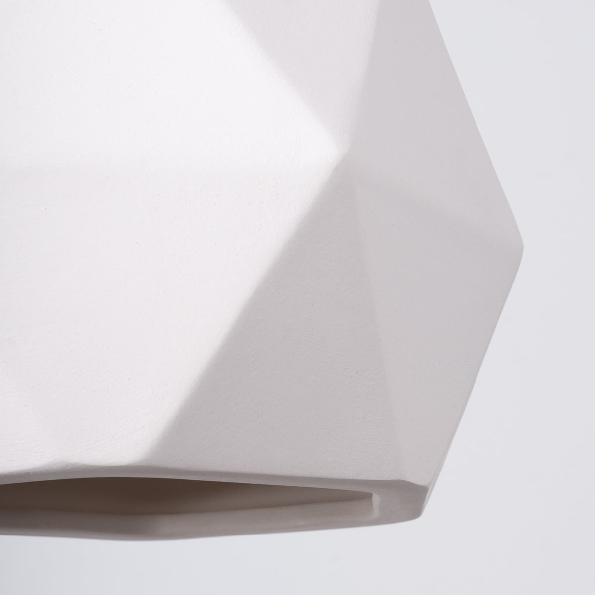 Détail des facettes en céramique blanche mate de la suspension Mint