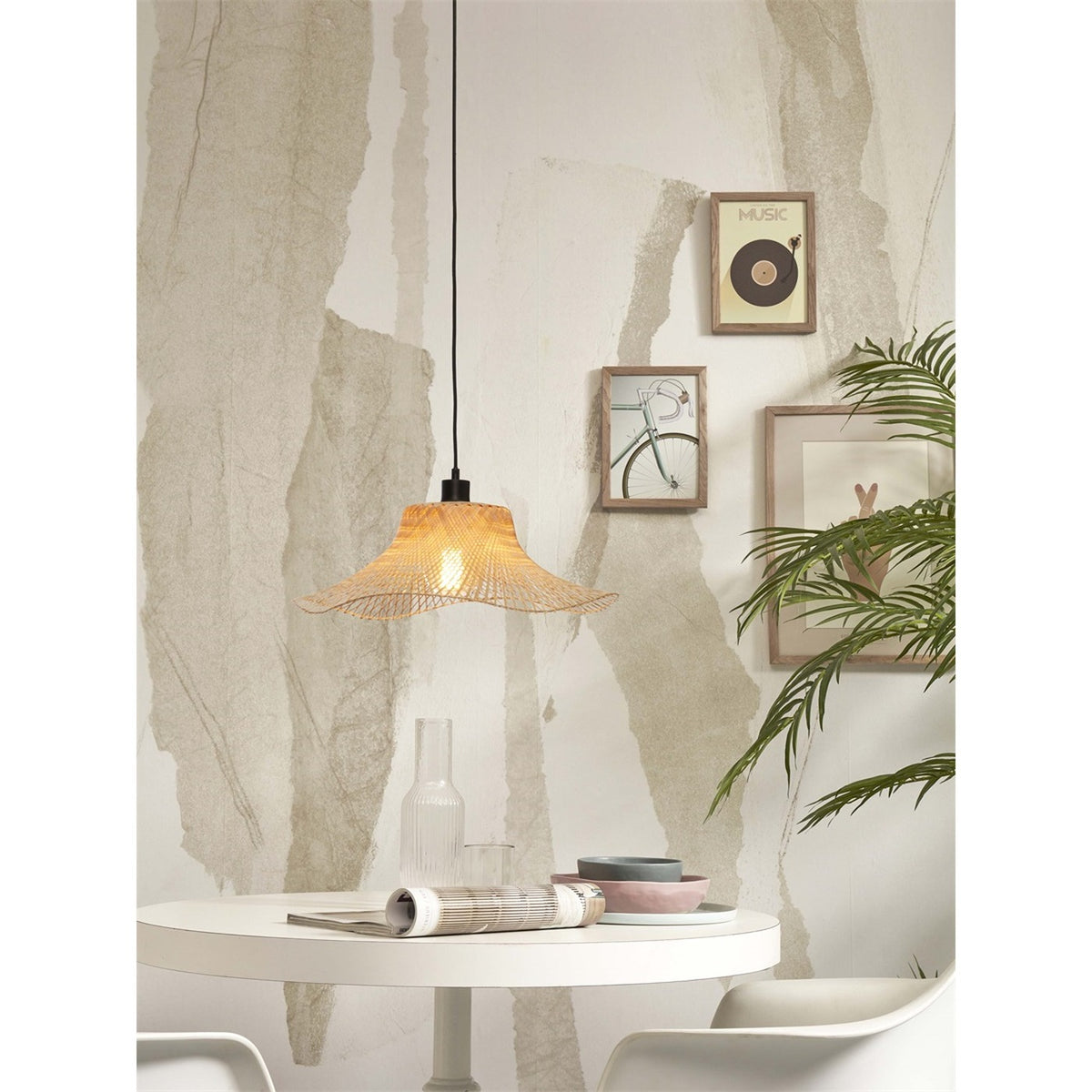 Suspension Ibiza Bambou naturel au-dessus d'une petite table ronde blanche devant des cadres au mur