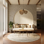 Suspension Koshi I en rotin naturel au-dessus d'un canapé en bois devant une niche en arche dans un salon
