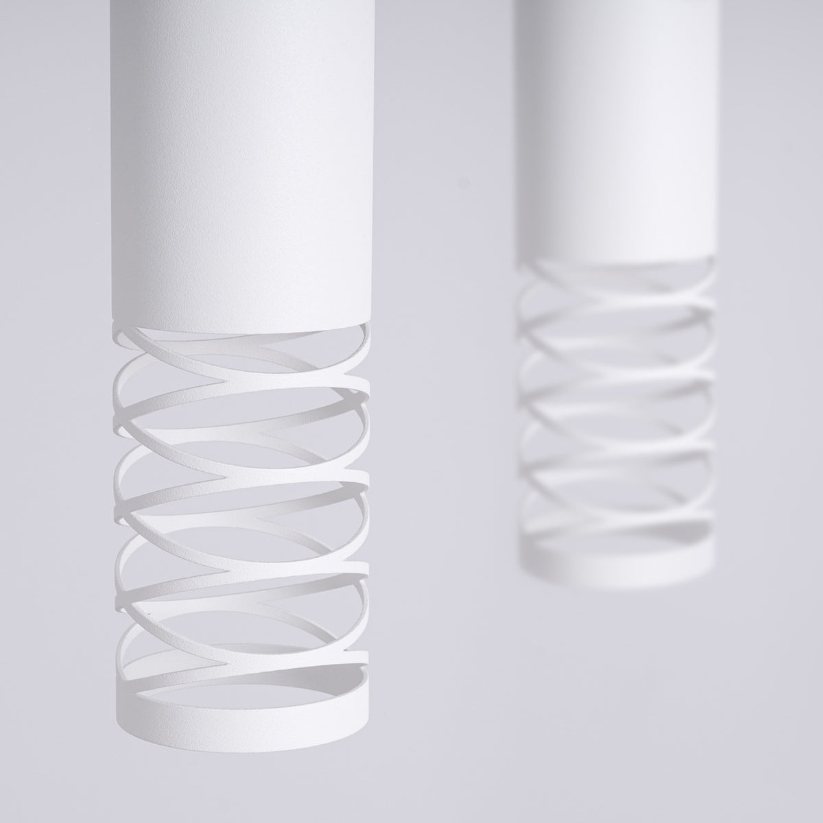 Gros plan sur la découpe en spirale des tubes en acier blanc mat de la suspension Lami 2