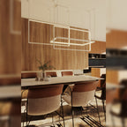 Suspension Geometric blanche allumée au-dessus d'une table en marbre entourée de chaises devant un mur en bois