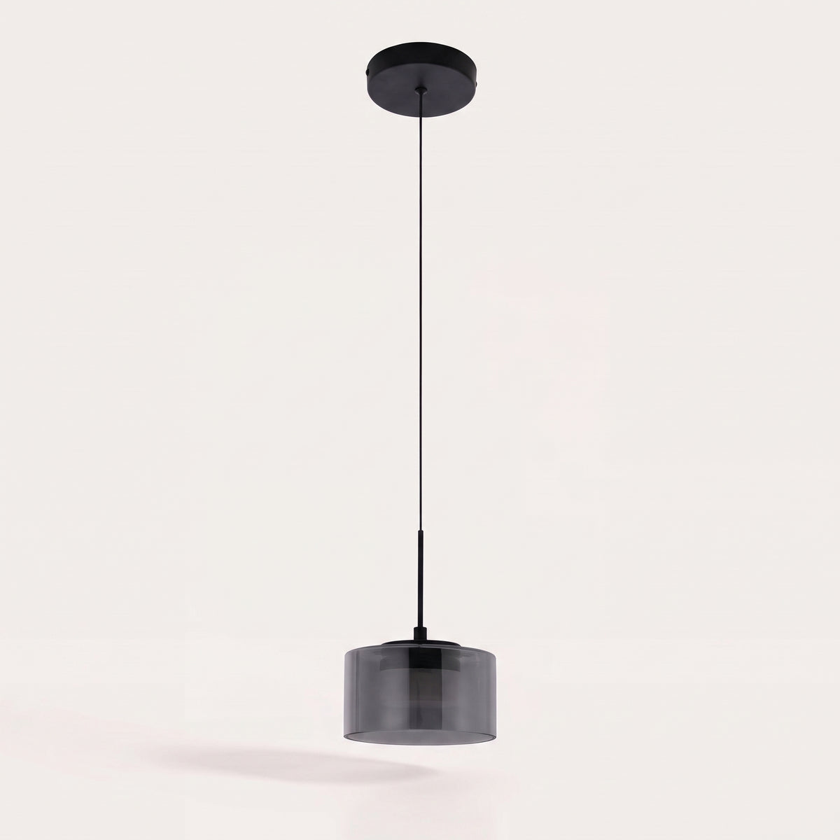 Suspension LED Cholet éteinte sur fond clair, cylindre en verre fumé, câble fin et rosace ronde en acier noir