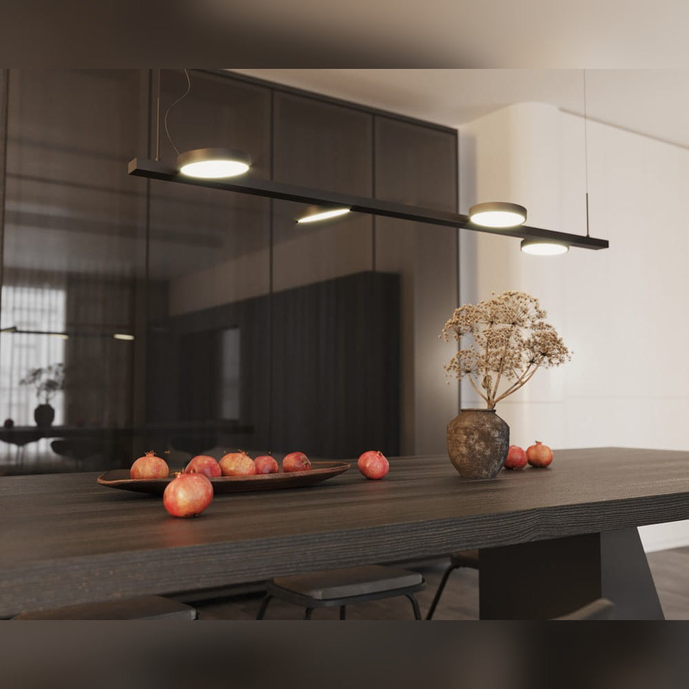 Suspension Ibiza allumée au-dessus d'une table en bois sombre avec grenades et vase de fleurs séchées