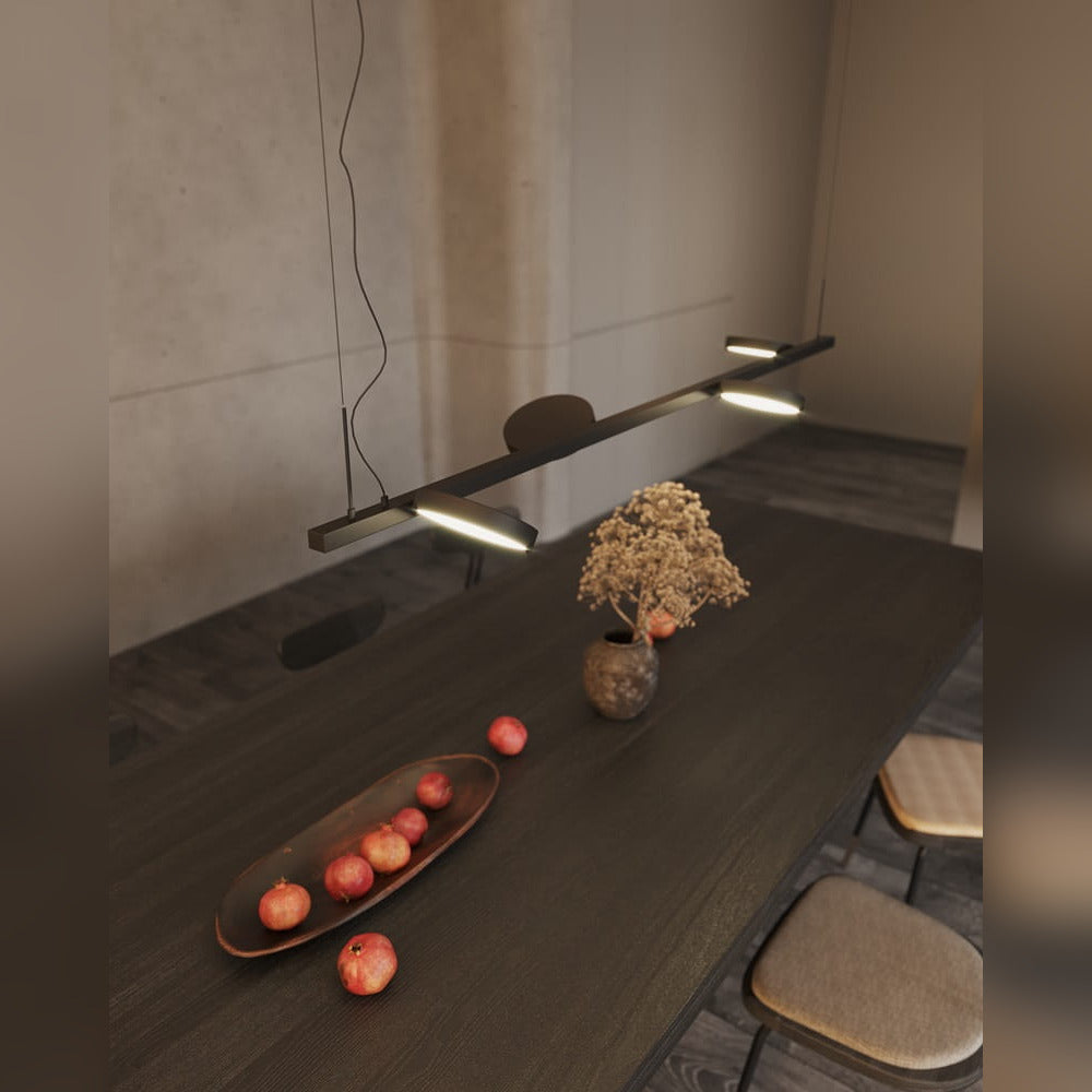 Suspension Ibiza noire vue de haut au-dessus d'une longue table en bois sombre disques inclinés allumés