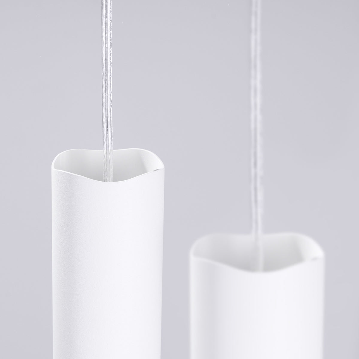 Haut ondulé des tubes en acier blanc de la suspension Liro traversés par leur câble transparent