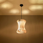 Suspension Oriana allumée projetant des taches de lumière au plafond entre ses lamelles de bois