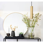 Suspension Paris laiton doré au-dessus d'une console noire avec miroir rond, ambiance chic