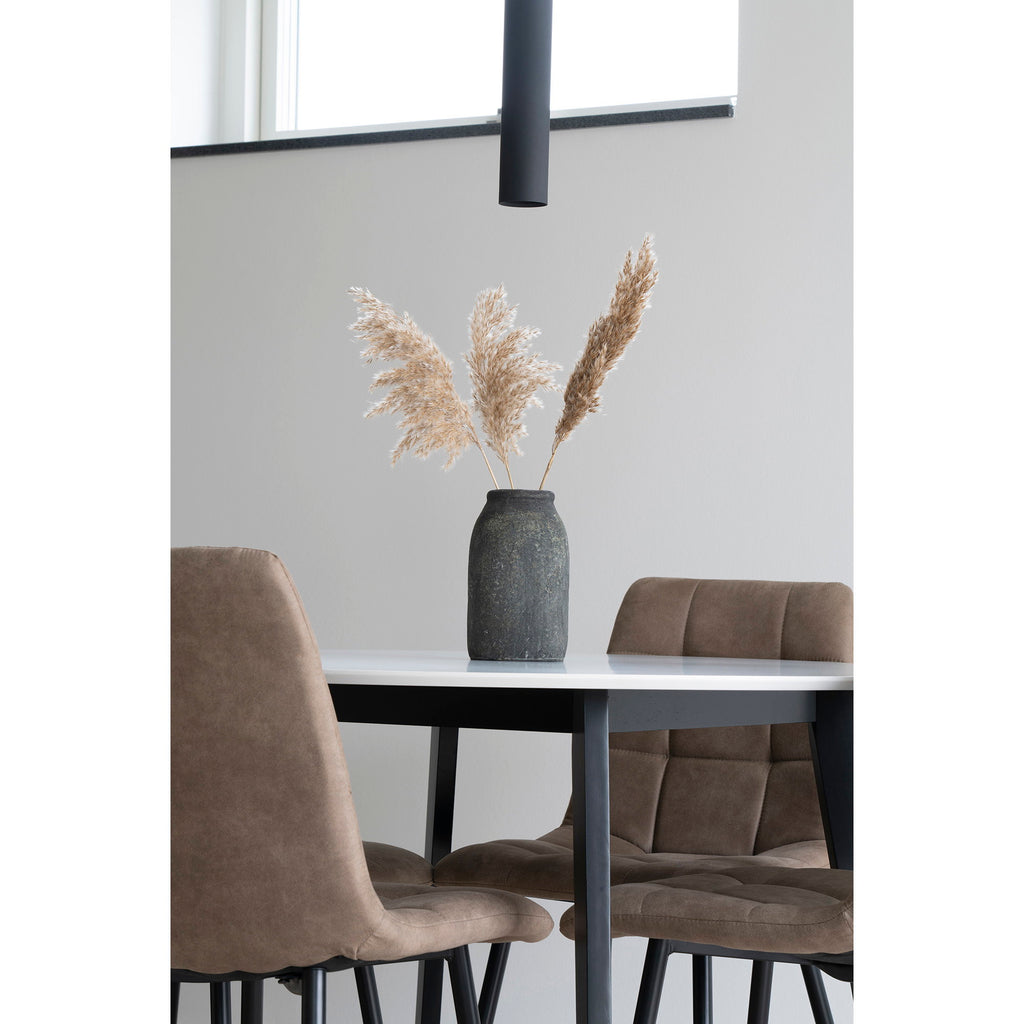 Suspension Paris noire vue rapprochée au-dessus table blanche, chaises velours taupe