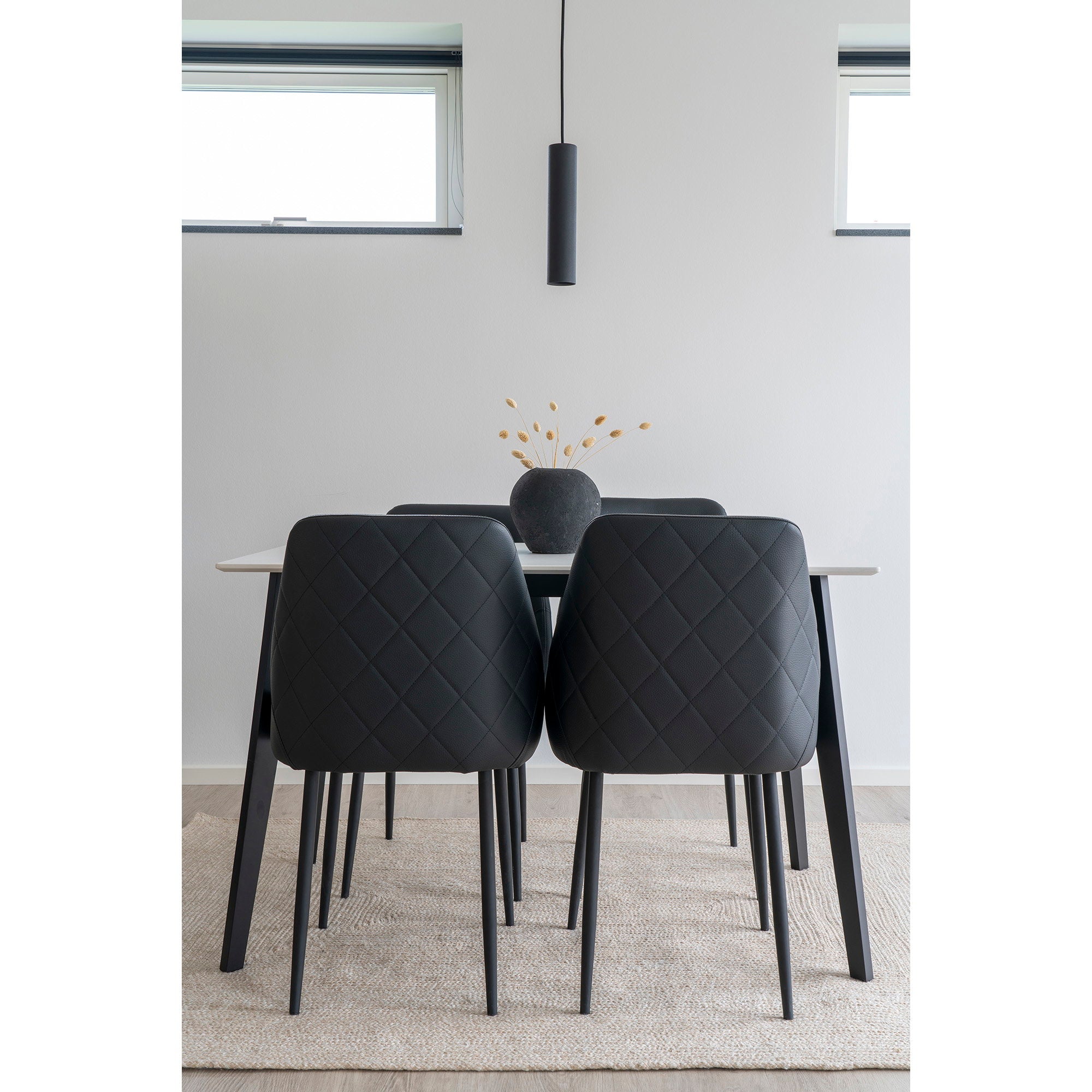 Suspension Paris noire au-dessus table à manger, chaises cuir noir, décoration minimaliste