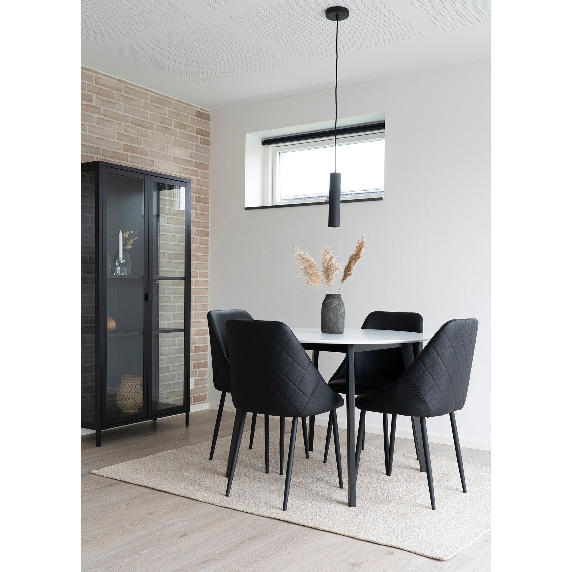Suspension Paris noire seule au-dessus table ronde blanche, chaises cuir noir, salle manger