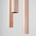 Suspension Pastelo 3 en grappe tubes fins bois G9, détail du tube de bois naturel