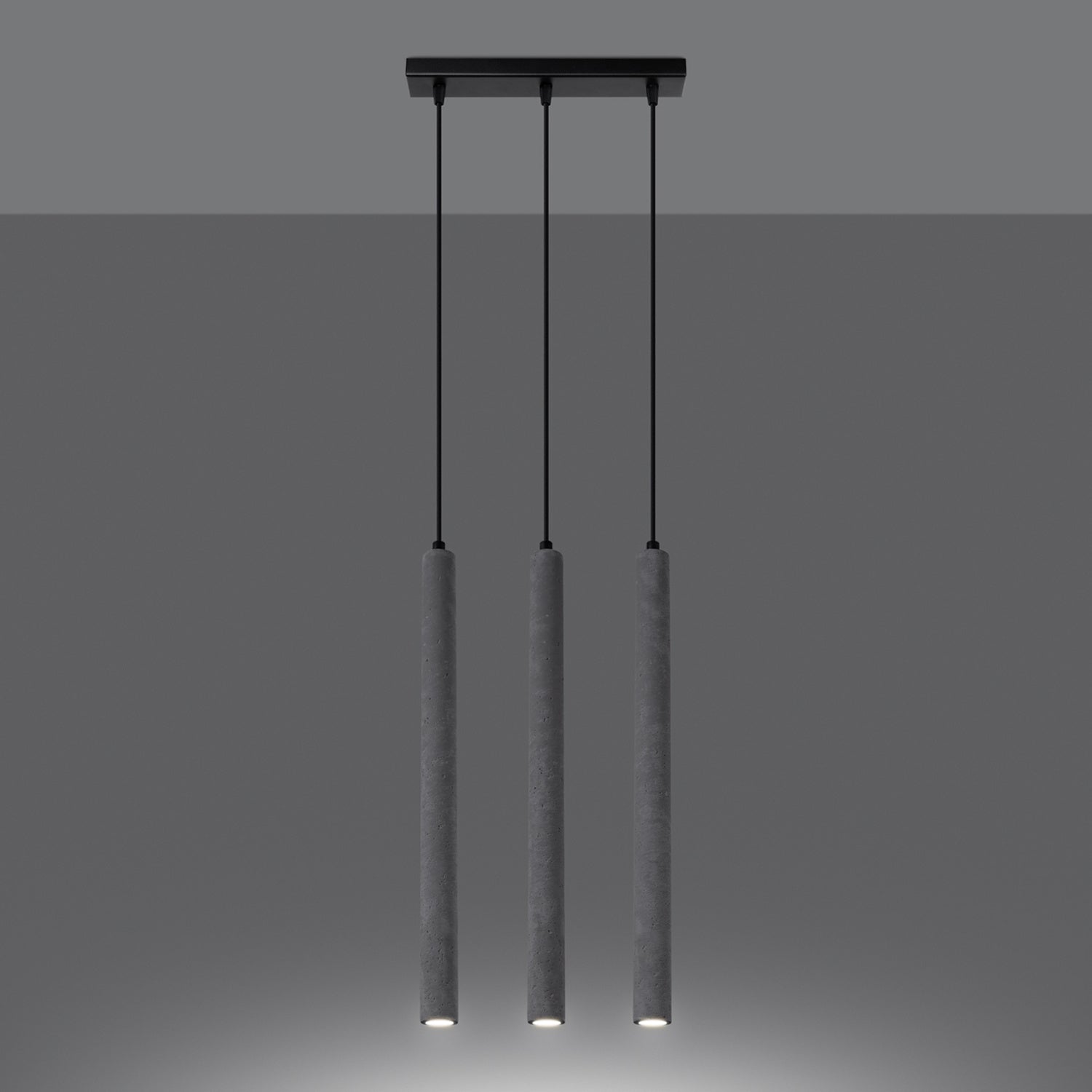 Suspension Pastelo 3 en ligne tubes fins béton gris G9 allumée, faisceau vers le bas