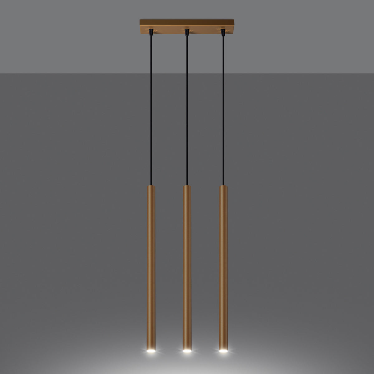 Suspension Pastelo allumée avec la lumière qui sort du bas de ses trois tubes dorés