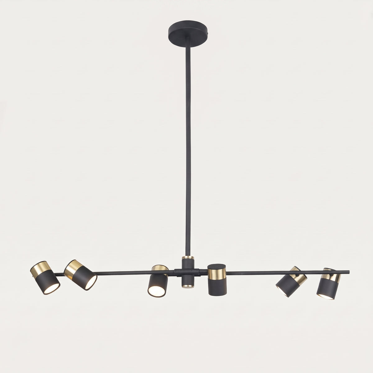Suspension Puma vue de face sur fond clair, barre noire à six spots orientables cerclés de doré sous une tige rigide