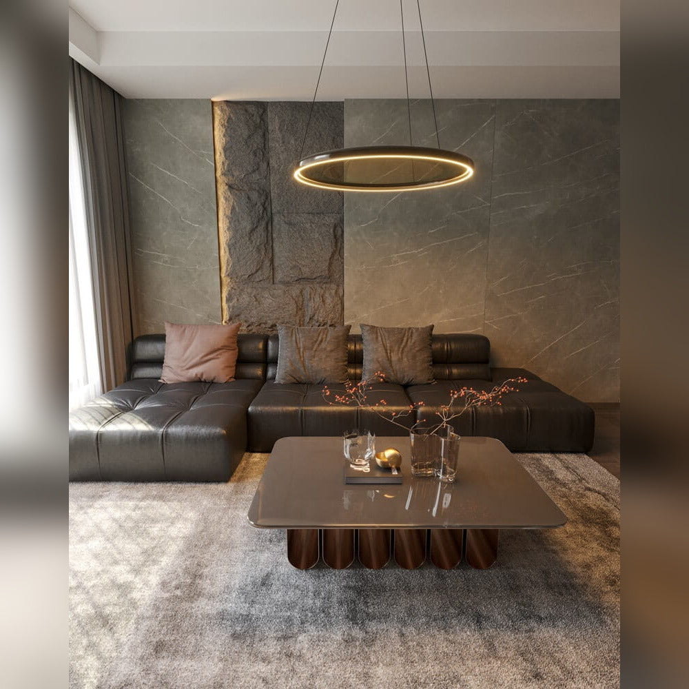 Suspension Qled allumée au-dessus d'un canapé sombre et d'une table basse dans un salon