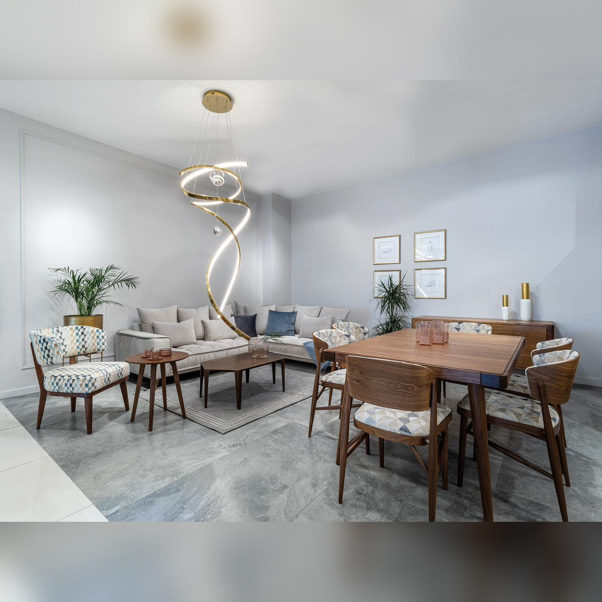 Suspension Ritz allumée dans un séjour contemporain entre un canapé clair et une table à manger en bois