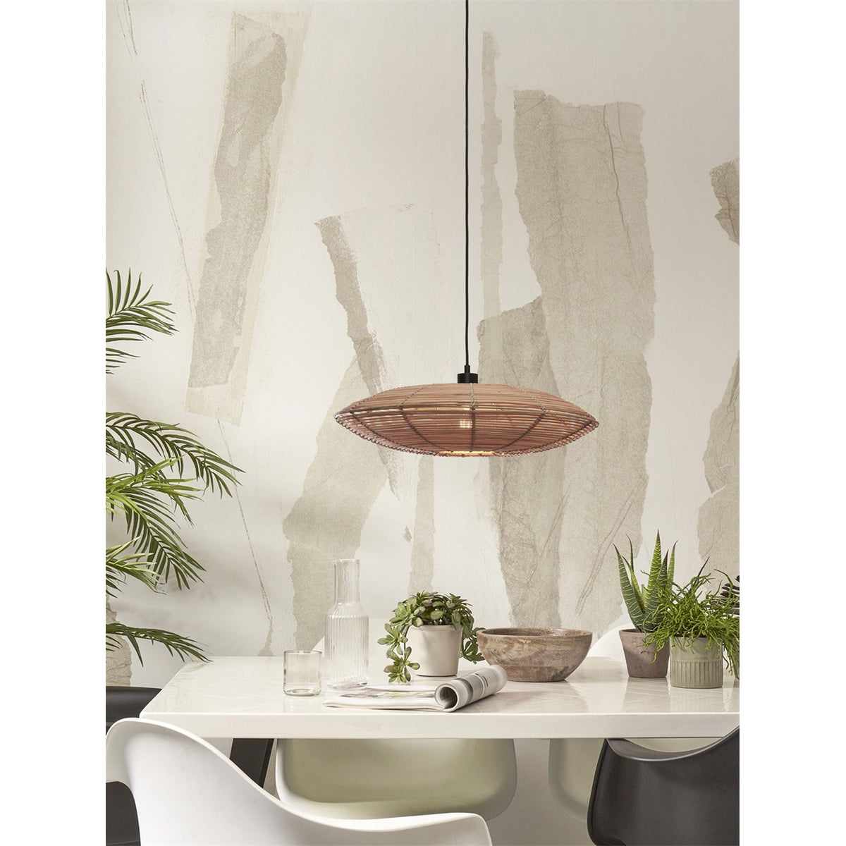 Suspension Tanami allumée au-dessus d'une table blanche garnie de plantes