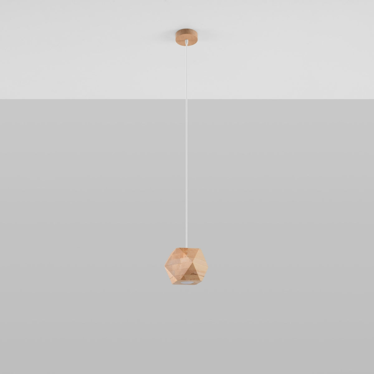 Suspension Woody en bois naturel pendue sous un plafond blanc devant un mur gris