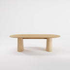 Table à manger Anchor 240 cm en chêne naturel vue de face sur ses deux socles en travertin