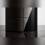 Détail du lest en béton de la table Sharp avec ses joints et sa découpe en biais contre le fût en acier noir