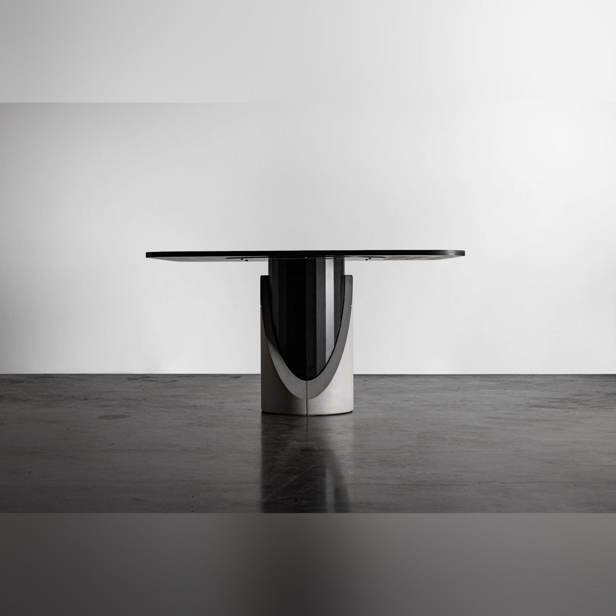 Table à manger Sharp vue de face avec le sous-plateau visible et la découpe en arche du lest en béton autour du fût