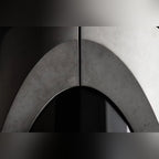Détail de l'arche formée par les deux demi-lests en béton autour du fût en acier noir de la table Sharp