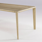 Angle du plateau et haut d'un pied de la table Raia en chêne naturel