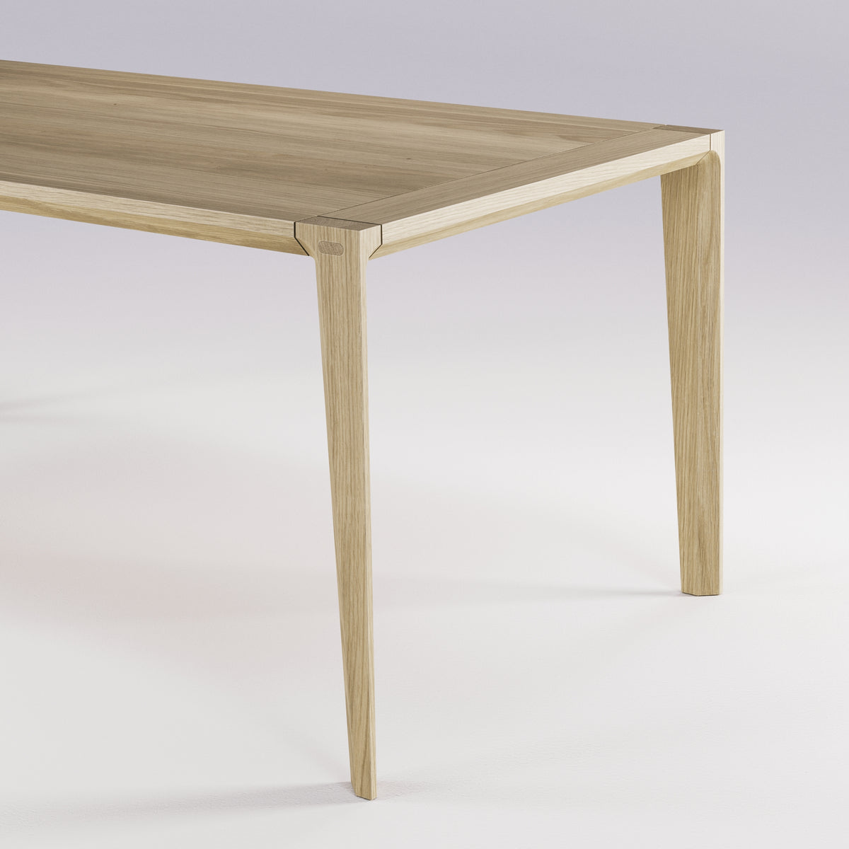 Angle du plateau et haut d'un pied de la table Raia en chêne naturel