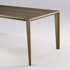 Angle du plateau et haut d'un pied de la table Raia en noyer foncé