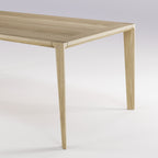 Angle du plateau et haut d'un pied de la table Raia en chêne naturel