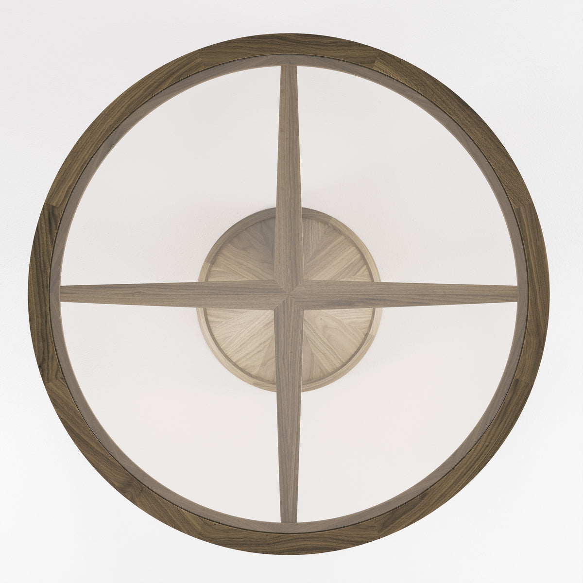 Croisillon de bois vu à travers le plateau de verre bronze de la table Vasco en noyer foncé