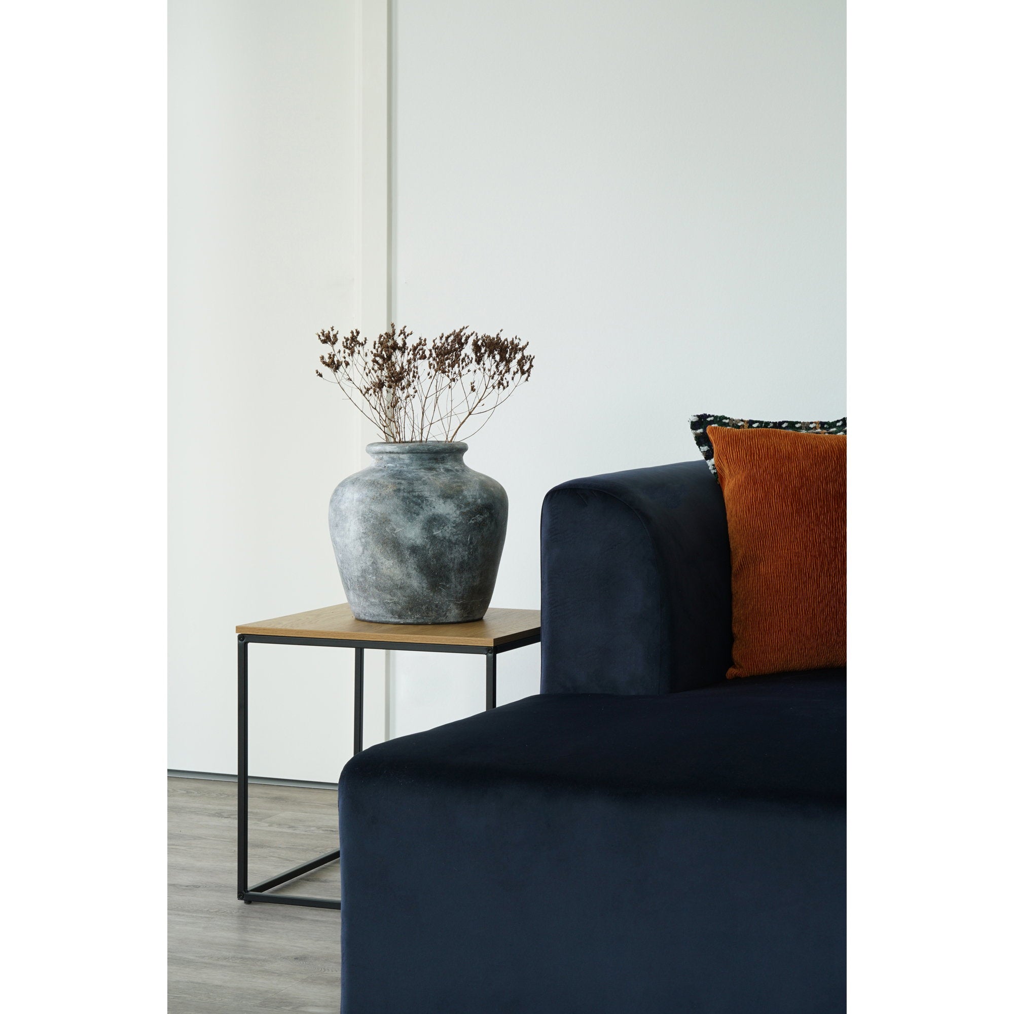 Table d'appoint Vita chêne naturel cadre noir 45x45 cm avec vase ambiancé canapé velours bleu