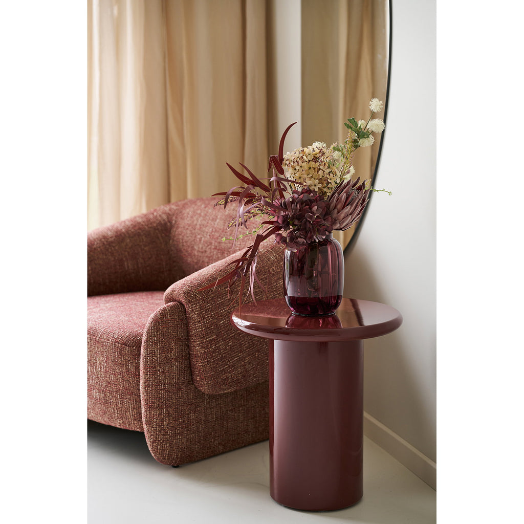 Table d'appoint Otago bordeaux brillant avec vase fleurs près fenêtre arquée salon lumière naturelle